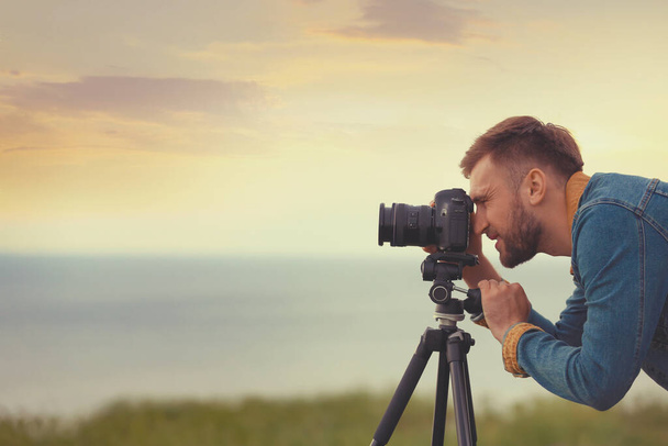 Photographer taking picture of beautiful landscape with professional camera outdoors. Space for text - Foto, Imagem