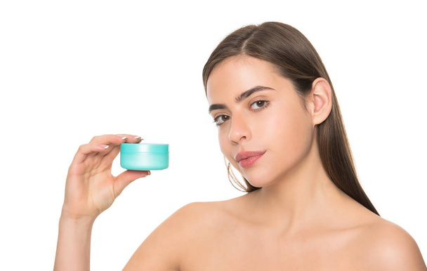 jonge dame tonen crème pot voor gezicht huid geïsoleerd op witte achtergrond met kopieerruimte, hydraterende balsem. - Foto, afbeelding