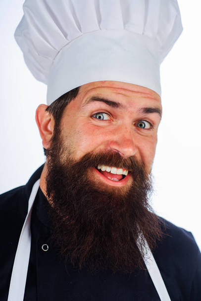 Бородач в форме. Мужчина повар или пекарь в белой шляпе и фартуке. Портрет улыбающегося шеф-повара. Кулинария - Фото, изображение