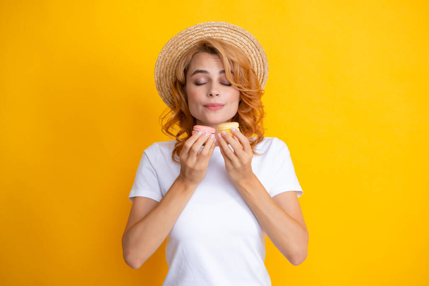 Porträt von stilvollen schönen hübsch niedlich sie ihr Mädchen mit Süßigkeiten Kekse Makrone isoliert auf gelbem Hintergrund - Foto, Bild