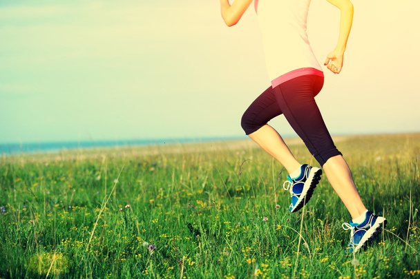 Athlète coureur courir sur l'herbe bord de mer. femme fitness jogging séance d'entraînement concept bien-être
. - Photo, image