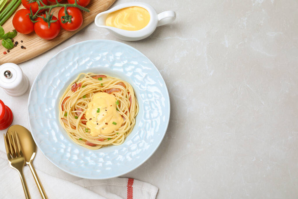 Pyszne spaghetti z sosem mięsno-serowym serwowane na jasnoszary stół, płaskie leżaki. Miejsce na tekst - Zdjęcie, obraz