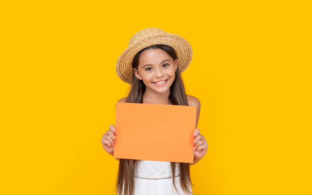 glad teen child with copy space on orange paper on yellow background. - Φωτογραφία, εικόνα