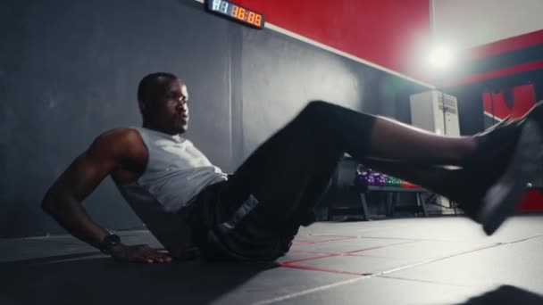 Ασκηθείτε μαύρο άντρα ταλάντευση τα πόδια του για να κάνει crossfit άσκηση και άρση βάρους μέσα γυμναστήριο γυμναστήριο. Δύναμη γυμναστικής σώματος και σφιχτός μυς κοιλιακών για τη σωματική υγεία σώματος. - Πλάνα, βίντεο