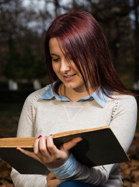 Univerzitní dívka sedí v parku a čtení knihy - Fotografie, Obrázek