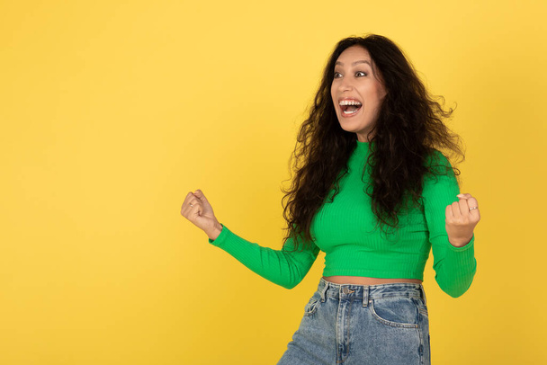 Emotional Middle Eastern Lady Gesturing Yes Looking Aside Celebrating Great Success Standing Over Yellow Background In Studio. Yes, I Did It, Victory Celebration Concept - Foto, Imagem