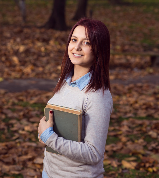 University girl in park reading a book - Foto, Bild