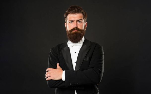 elegant butler in tuxedo on black background, fashionist. - Zdjęcie, obraz