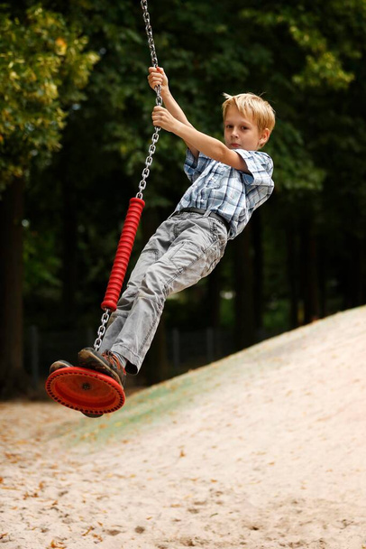 Boy, 10 years, on a zip line on a playground - Foto, afbeelding
