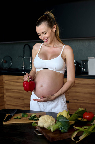 Beautiful pregnant woman making fruits smoothies with blender. Healthy pregnant eating lifestyle concept - Foto, imagen