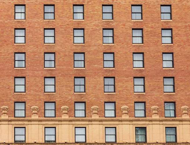 Many windows in row on facade of urban apartment building. Brick building. Street photo, nobody, selective focus - Fotografie, Obrázek