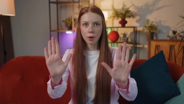 Stop gesture. Angry redhead child girl say No hold palm folded crossed hands, warning of finish, prohibited access, declining communication, body language, danger. Kid at home room apartment indoors - Filmati, video