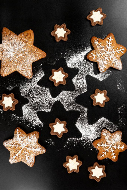Πάνω άποψη του νιφάδες χιονιού gingerbread και μπισκότα αστέρια σε σκούρο bac - Φωτογραφία, εικόνα