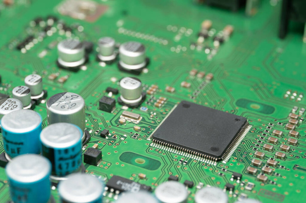 chip on green pcb board. Electronic circuit board close up. - 写真・画像