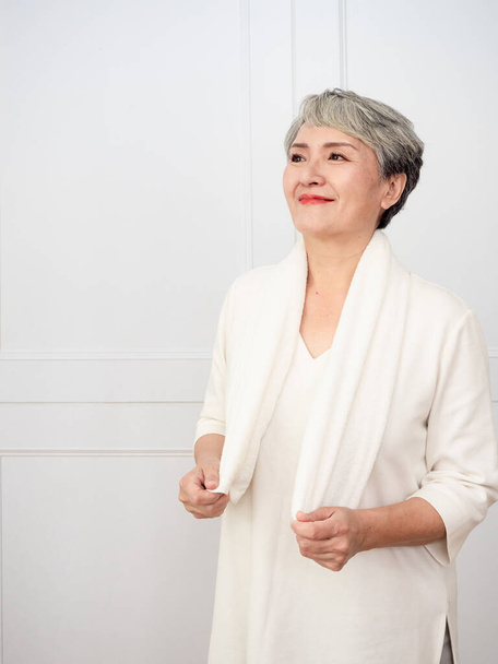 Portrait of mature aged asian woman 50s with towel at home. - Fotó, kép