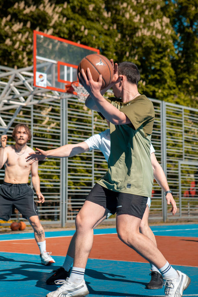 Львів, Україна - 12 травня 2022: чоловіки грають у баскетбол на відкритому повітрі, копіюючи простір - Фото, зображення