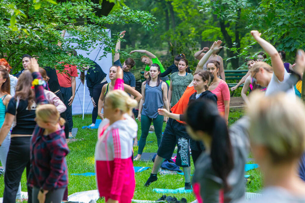 Lviv, Ukraine - July 2, 2021: lot of people at city park do yoga close up - Foto, afbeelding