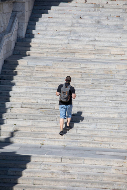 personas caminando por escaleras de piedra con mochila día soleado - Foto, imagen