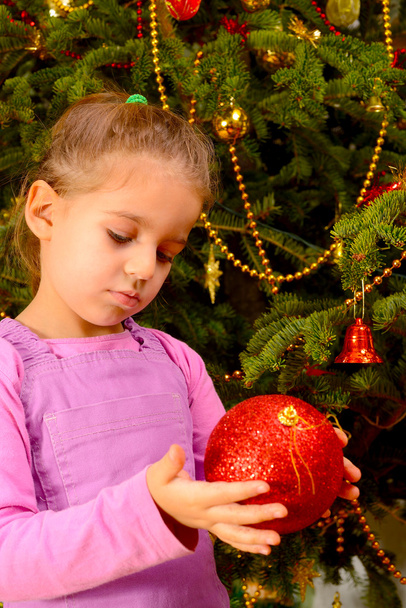 Roztomilé batole dívka drží dekorativní vánoční hračka míč - Fotografie, Obrázek