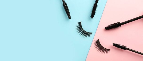Black mascara and fake eyelashes on color background with space for text - Photo, Image