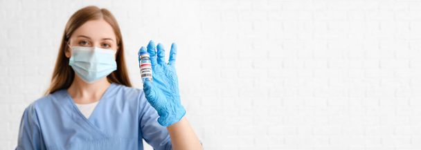 Female doctor holding monkeypox vaccine on white background with space for text - Photo, image