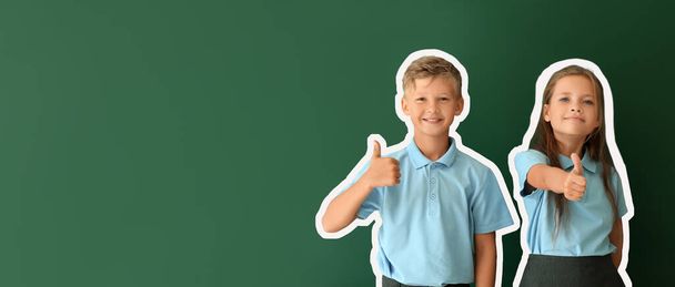 Kis iskolások mutatják hüvelykujj-up zöld háttérrel helyet a szöveges - Fotó, kép