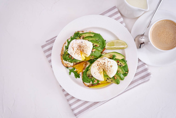 Freshly made poached egg and Avocado toasts on light grey background. - Foto, Imagen