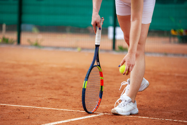 Female tennis player legs in tennis shoes standing on a clay court close up. - Valokuva, kuva