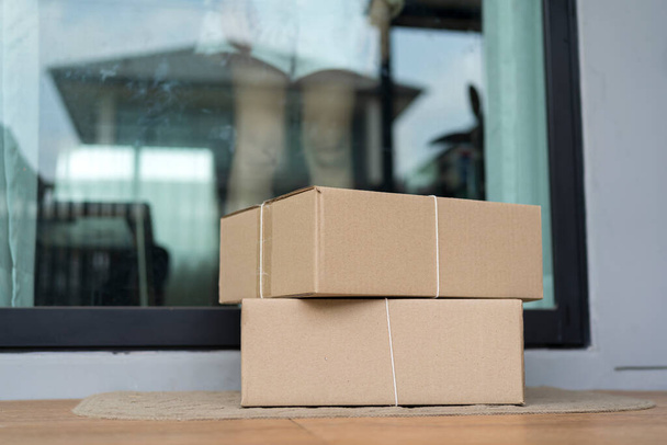 Deliver parcels box on door mat near home entrance door. Delivery online order to home - Фото, изображение