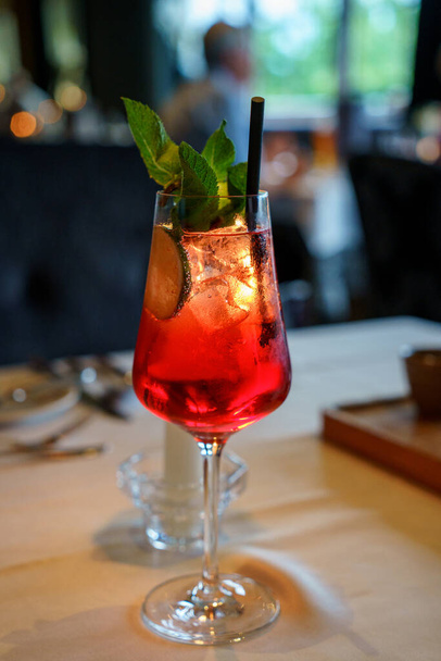 klassischer Aperol-Cocktail an der Bar, klassischer italienischer Aperol-Spritz-Cocktail im Glas auf dunkel. Konzept der Getränkekarte hautnah - Foto, Bild