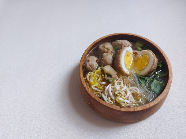 egg meatballs. completed with mustard greens, sprouts, yellow noodles, sound.  served on wooden bowls.  savory taste.  isolated background in white. - 写真・画像