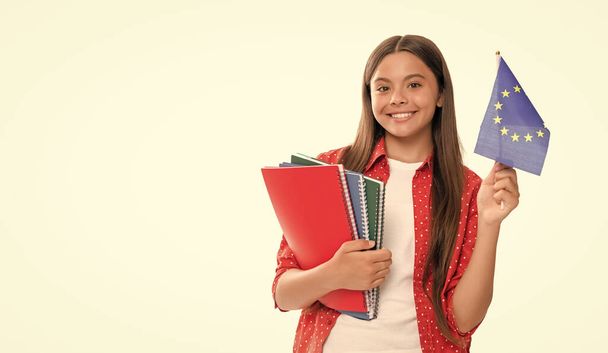 back to school. education abroad for child. kid study abroad. travel and learn foreign language. cheerful teen girl hold european union flag and workbook. schengen countries. touristic visa. - Photo, Image