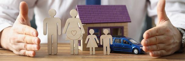Detailní záběr obchodního zástupce navrhnout postarat se o zdravotní, auto a pojištění domu. Miniaturní model rodiny, budovy a auta. Koncept ochrany - Fotografie, Obrázek