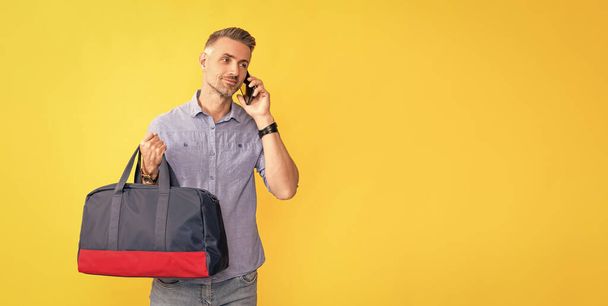 communication. businessman speak on smartphone with travel bag. man has conversation hold sports bag. phone call negotiation. voice contact like mobile technology. talk on cellphone. copy space. - Fotoğraf, Görsel