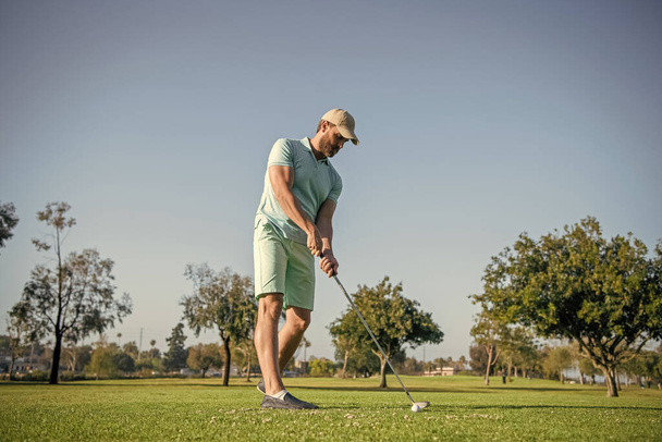 Profesyonel açık hava sporu. Profesyonel golf sahasında erkek golfçü. Golf sopasıyla şapkalı golfçünün portresi. İnsanların yaşam tarzı. Yeşil çimlerde oyun oynayan sporcu adam. yaz etkinliği. - Fotoğraf, Görsel