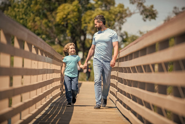 cheerful father walking with his son outdoor, friendship. - Фото, зображення