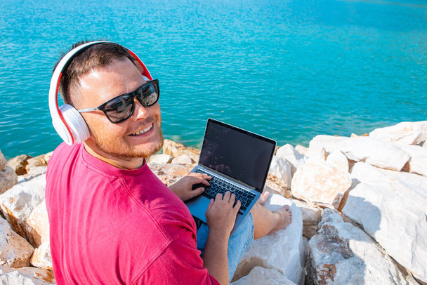 человек фрилансер, работающий на ноутбуке в городской гавани летом - Фото, изображение