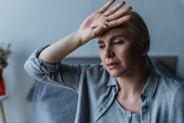 tired blonde woman with menopause suffering from heat in bedroom - Fotografie, Obrázek