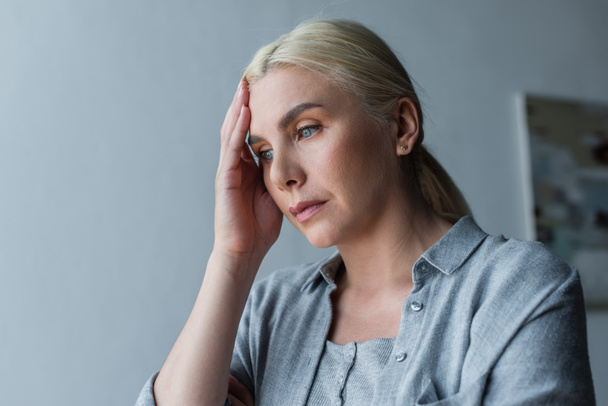 depressed woman with menopause touching forehead and looking away - Fotografie, Obrázek