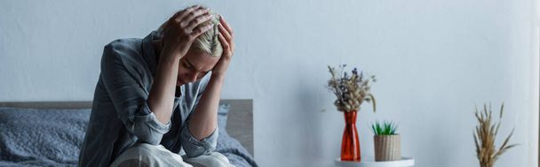 blonde woman touching head while suffering from pain during menopause, banner - Photo, image