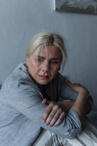 blonde and depressed woman with blue eyes feeling unwell during menopause  - Φωτογραφία, εικόνα