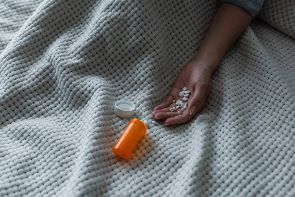 cropped view of depressed woman with climax holding pills in hand  - Фото, изображение