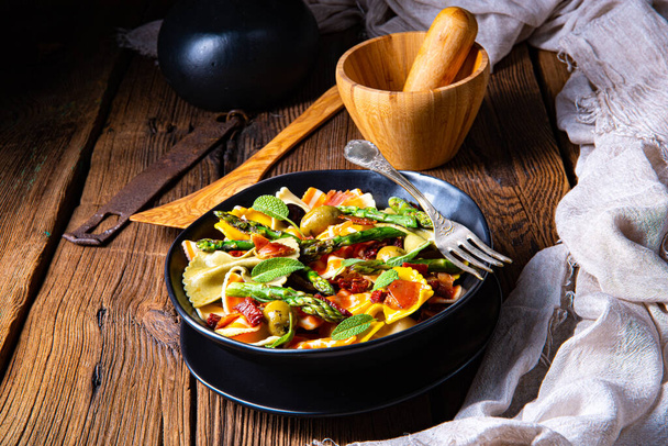 Pasta salad with green asparagus, olives and parma ham - Foto, afbeelding