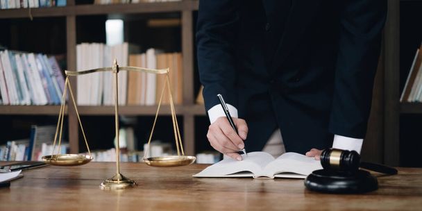Justitie en recht concept.Man rechter in een rechtszaal op houten tafel en raadsman of mannelijke advocaat in functie. Juridisch recht, advies en rechtsbegrip - Foto, afbeelding