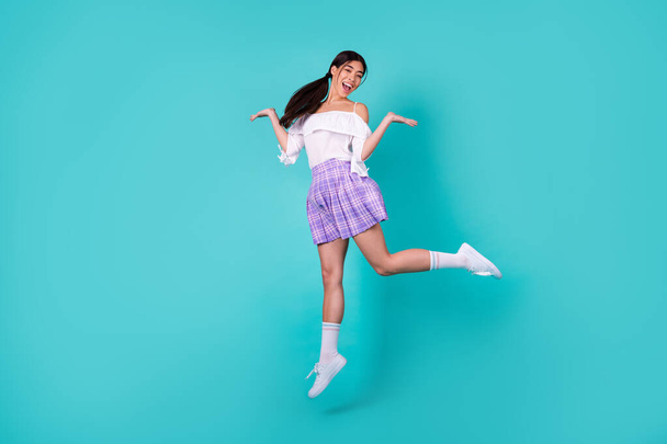 Full size photo of cheerful carefree lovely thai person jumping have fun isolated on cyan color background. - Foto, Imagen