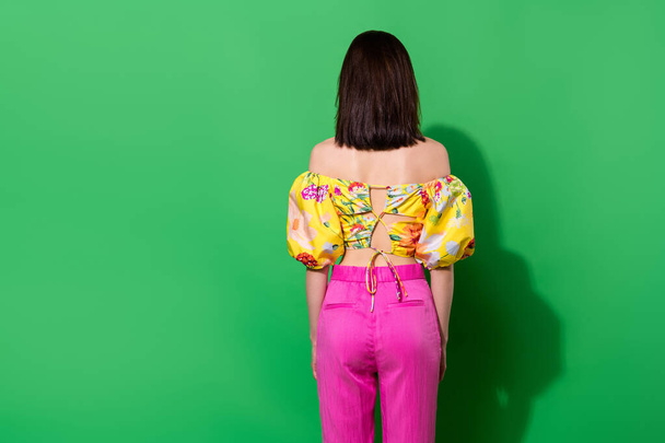 Photo of sweet slender girl dressed off shoulders standing back empty space isolated green color background. - Foto, Imagem