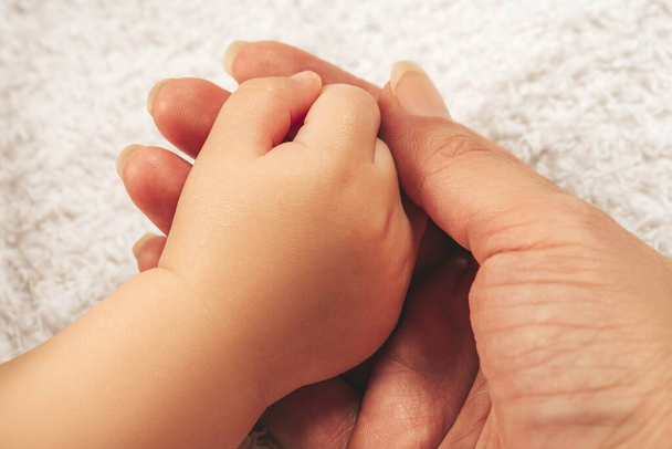 Female hand holding boy baby's hand - Fotoğraf, Görsel