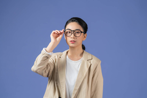 Asijské mladé krásné žena paže drží ruku úpravy módní sluneční brýle na fialovém pozadí. - Fotografie, Obrázek