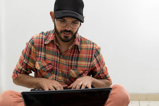 Латиноамериканец со своим ноутбуком программист и специализируется на веб-разработке. - Фото, изображение