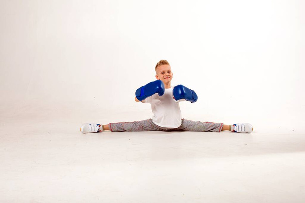 Young athlete sits on a splits on a white background - Foto, Imagen